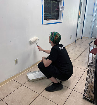 A Discount Dance staff member painting a wall